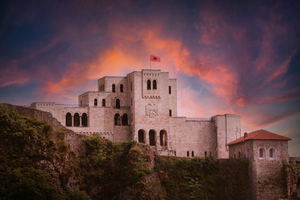 Kruje Castle with Albanian Flag on the roof and sunset in background