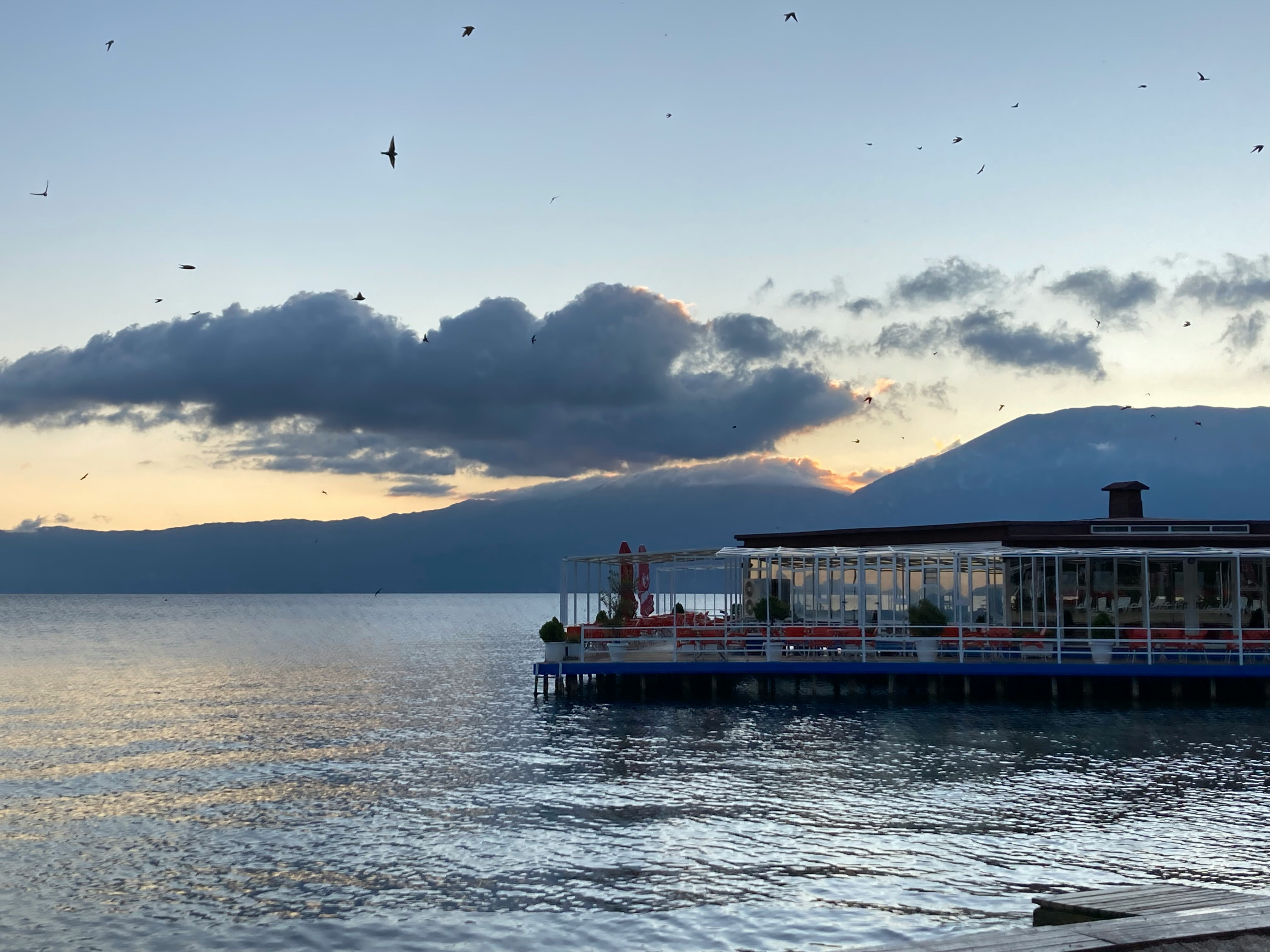 View at sunset of Lake Ohrid with birds in the clouds