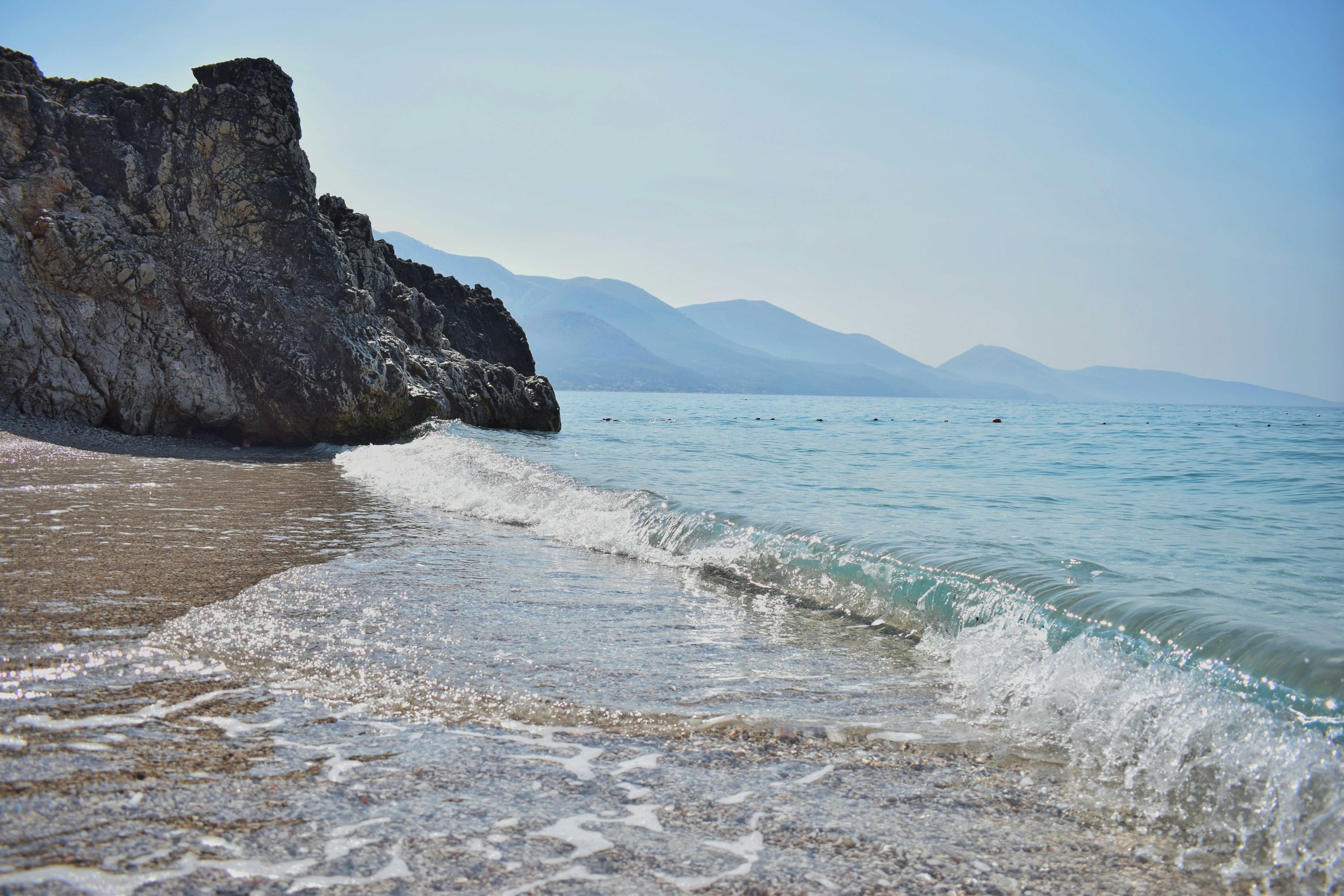 White sand beach with rocky mountain in background